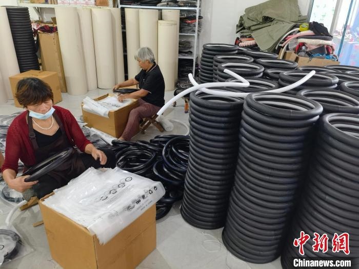 圖為村民在汽車飾品企業(yè)生產(chǎn)車間中工作。　呂子豪 攝