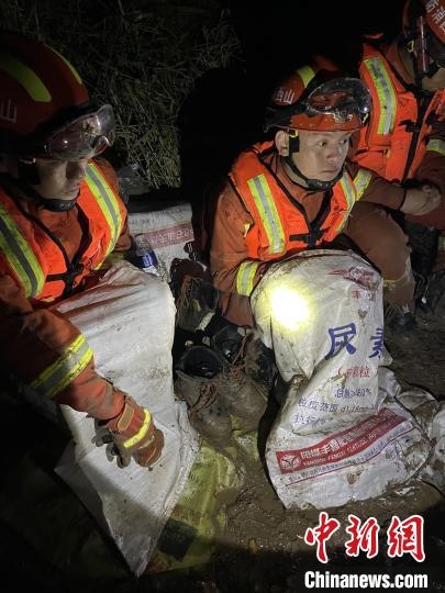短暫修整期間，消防員脫掉鞋襪，用編織袋套住腿腳保暖。　閆旭輝 攝