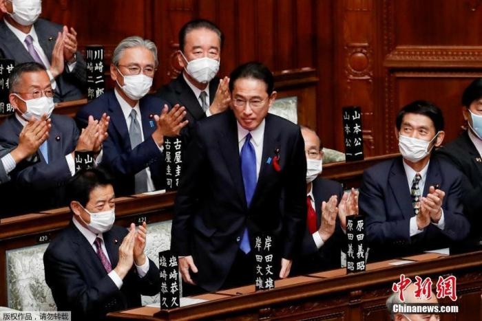 當?shù)貢r間10月4日，日本自民黨總裁岸田文雄經(jīng)過眾院全體會議的首相指名選舉成為第100任首相。圖為岸田文雄（中）起身致謝。