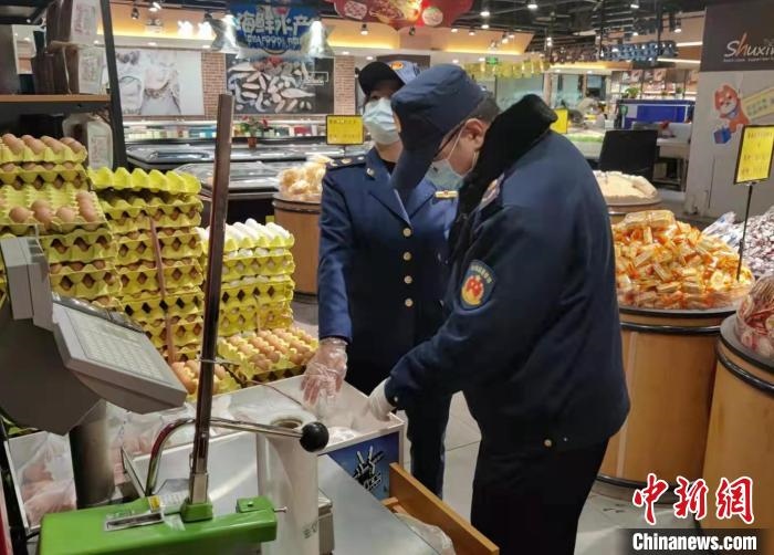 圖為疫情期間，甘肅嘉峪關(guān)市場監(jiān)管局工作人員檢查蔬菜市場?！?柴佳楠 　攝