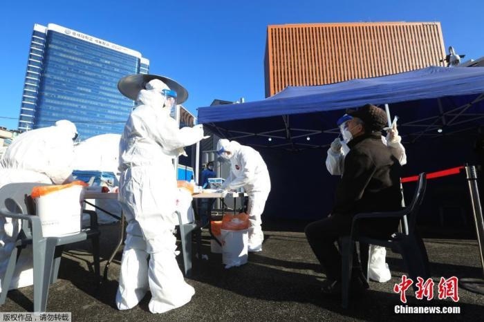 資料圖：韓國首爾，醫(yī)務(wù)人員對市民進行新冠病毒檢測。