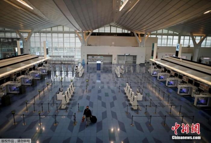 資料圖：日本東京，東京國際機場，一名乘客在國際航班航站樓的登機區(qū)。