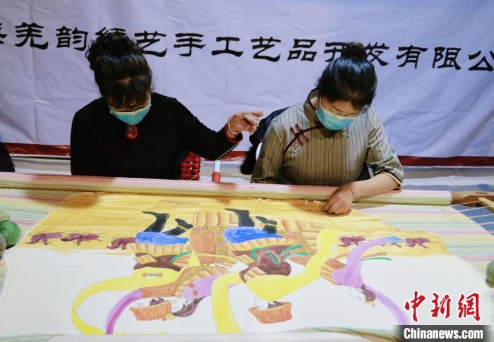 圖為皮繡藝人在市集上“秀”指尖技藝?！●R銘言 攝