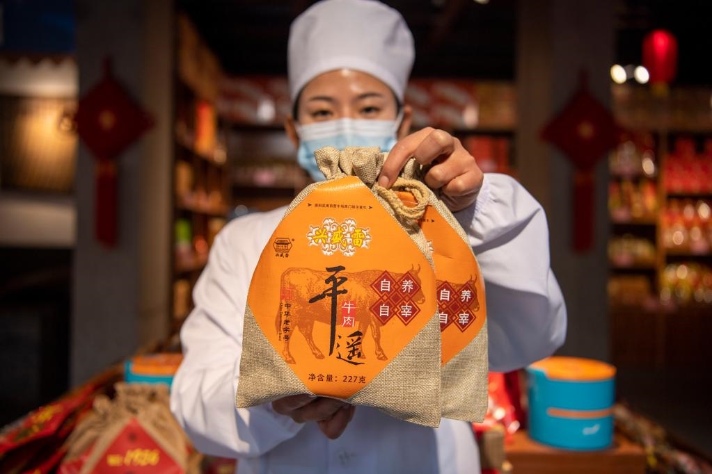 1月27日，在平遙古城南大街的一家平遙牛肉店內，工作人員展示一款牛肉產品。新華社記者 楊晨光 攝