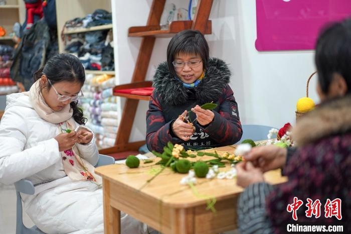 文創(chuàng)工作室的姐妹們正在鉤織月桂葉片。　古良駒 攝