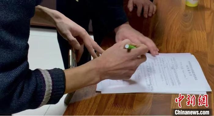 圖為現(xiàn)場下達詢問通知書。　李婷婷 攝