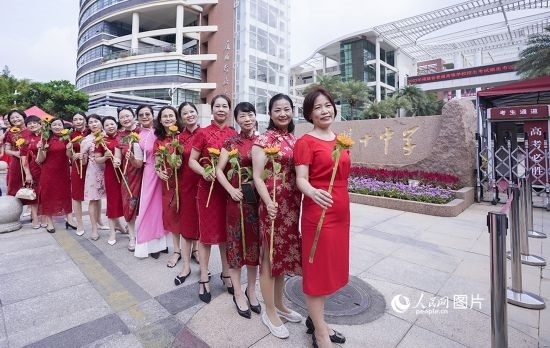 6月7日一早，廈門(mén)雙十中學(xué)考生家長(zhǎng)們身穿旗袍，手拿向日葵在考場(chǎng)外為孩子加油打氣，寓意“旗開(kāi)得勝，一舉奪魁”。人民網(wǎng)記者 陳博攝
