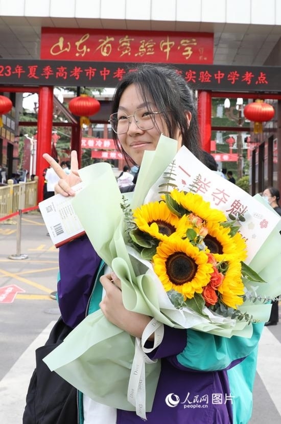 6月7日高考首日，山東67萬(wàn)考生走進(jìn)考場(chǎng)，拼搏逐夢(mèng)。在山東省實(shí)驗(yàn)中學(xué)考點(diǎn)，考生進(jìn)考場(chǎng)前手捧向日葵花拍照留念，寓意“一舉奪魁”。人民網(wǎng)記者 劉祺攝
