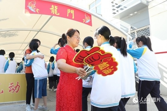 6月7日一早，雄安新區(qū)安新中學(xué)老師在給同學(xué)們加油鼓勁兒。人民網(wǎng) 李兆民攝