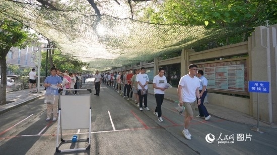 6月7日，烏魯木齊市第七十中學(xué)門(mén)口，考生們有序進(jìn)入考場(chǎng)。人民網(wǎng) 李欣洋攝