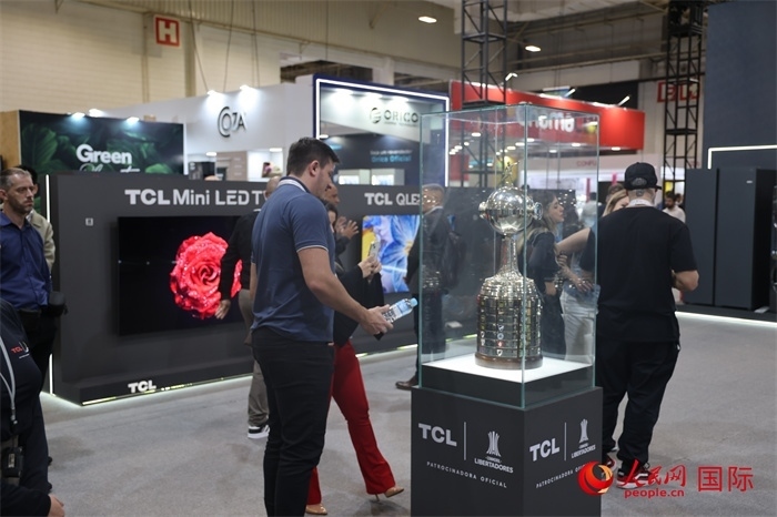 參觀者在TCL展臺前觀看南美解放者杯獎杯，據(jù)介紹，TCL是南美解放者杯（2023—2026賽季）全球官方合作伙伴。（人民網(wǎng)記者 時元皓攝）