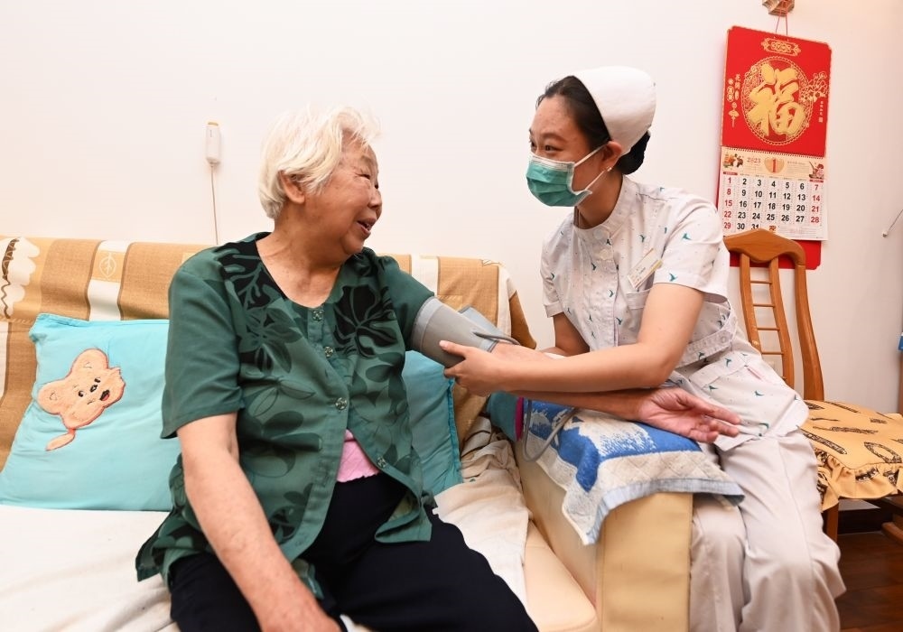 河北廊坊三河市燕達(dá)金色年華健康養(yǎng)護(hù)中心醫(yī)務(wù)人員為入住老人測量血壓（2023年7月20日攝）。新華社記者 朱旭東 攝