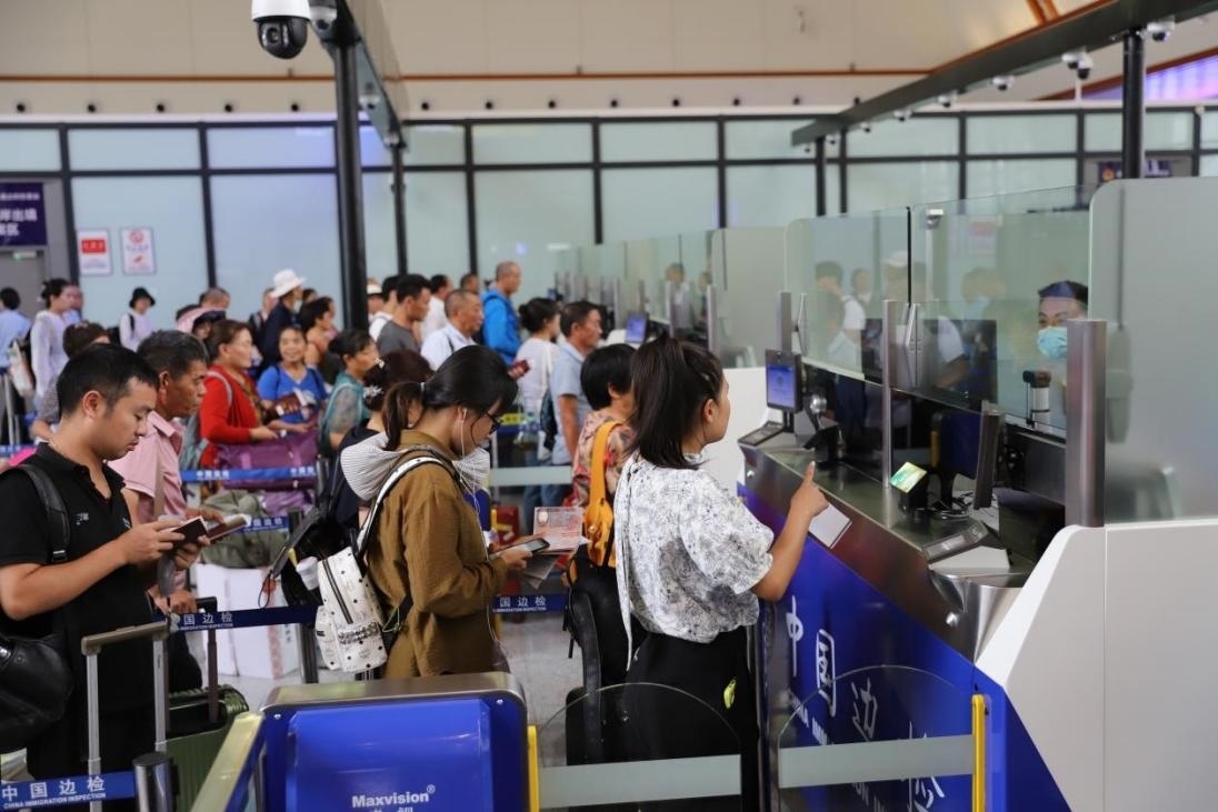 出境旅客在辦理通關手續(xù)。人民網記者 李發(fā)興攝