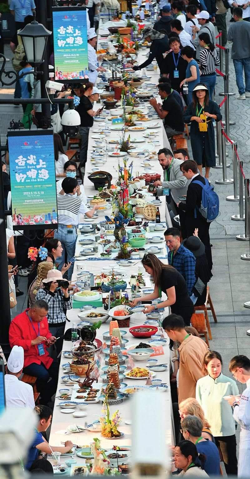 市民和游客在寧波舉辦的第三屆中國—中東歐國家博覽會(huì)暨國際消費(fèi)品博覽會(huì)上品嘗融合中國和中東歐美食的長桌宴（2023年5月15日攝）。黃宗治攝/本刊