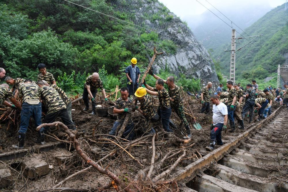 8月1日，在北京市門頭溝區(qū)水峪嘴村附近一段被阻斷的鐵路線上，中鐵六局工作人員在清理軌道上的雜物，全力恢復(fù)交通。新華社記者 鞠煥宗 攝