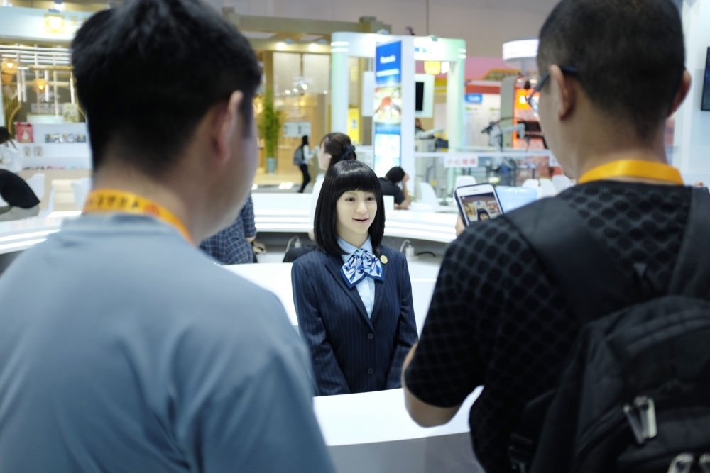 9月1日，媒體記者在國(guó)家會(huì)議中心與服務(wù)機(jī)器人互動(dòng)。新華社記者 劉夢(mèng)琪 攝