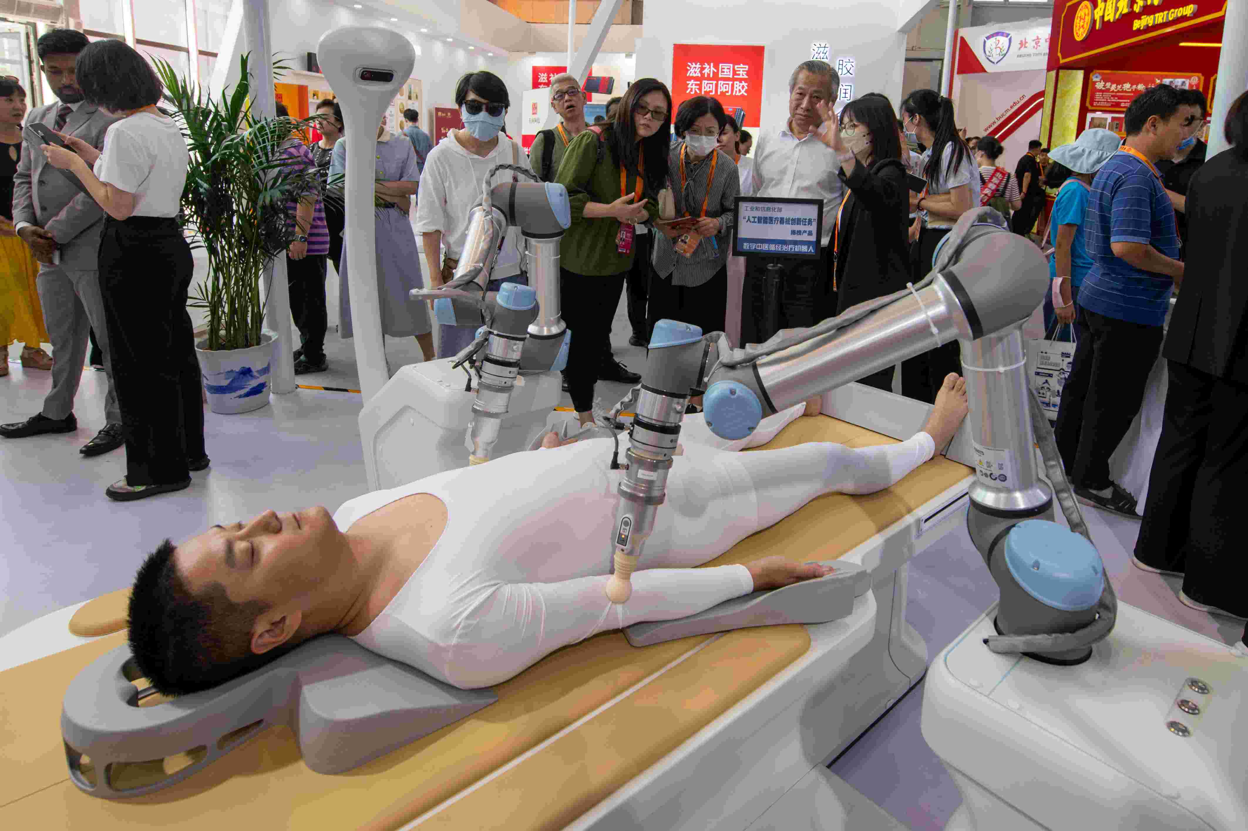 在位于首鋼園的健康衛(wèi)生服務(wù)展區(qū)，觀眾正在參觀數(shù)字中醫(yī)循經(jīng)治療機(jī)器人。人民網(wǎng)記者 翁奇羽攝