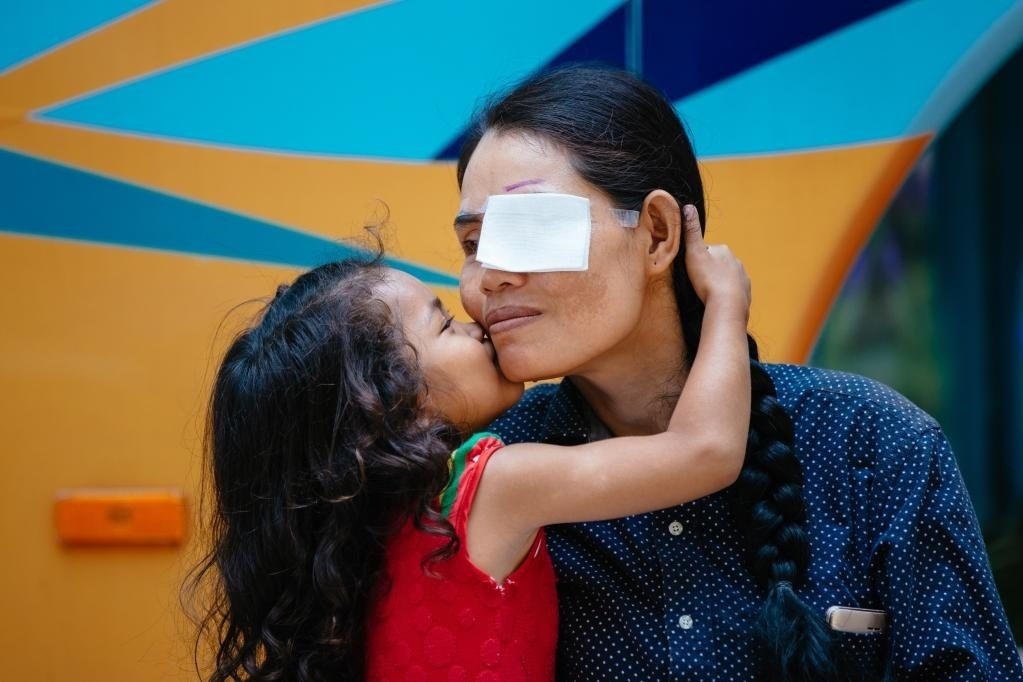 2019年3月15日，在柬埔寨磅湛省醫(yī)院，即將接受白內(nèi)障手術(shù)的患者孫美樂接受女兒的親吻祝福。在接受了中國醫(yī)療隊(duì)的白內(nèi)障義診手術(shù)后，她的視力逐步恢復(fù)，生活有了新的光明和希望。