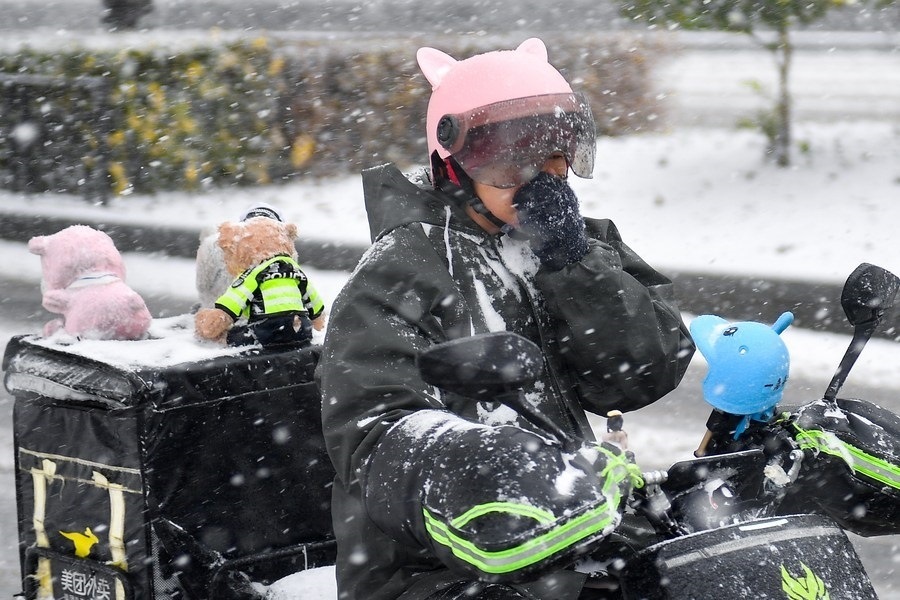 11月6日，在長(zhǎng)春市街頭，一名外賣員在雪中騎行。新華社記者 許暢 攝