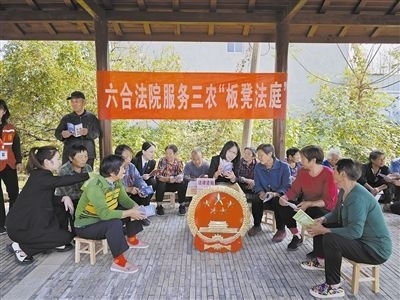  圖③：干警向附近農(nóng)戶解讀相關法律法規(guī)。