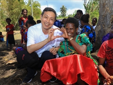 2023年12月18日，中國駐瓦努阿圖大使李名剛和前來觀看瓦努阿圖公路項(xiàng)目二期馬勒庫拉段移交儀式的當(dāng)?shù)鼐用窈嫌?。人民網(wǎng) 賀吉攝