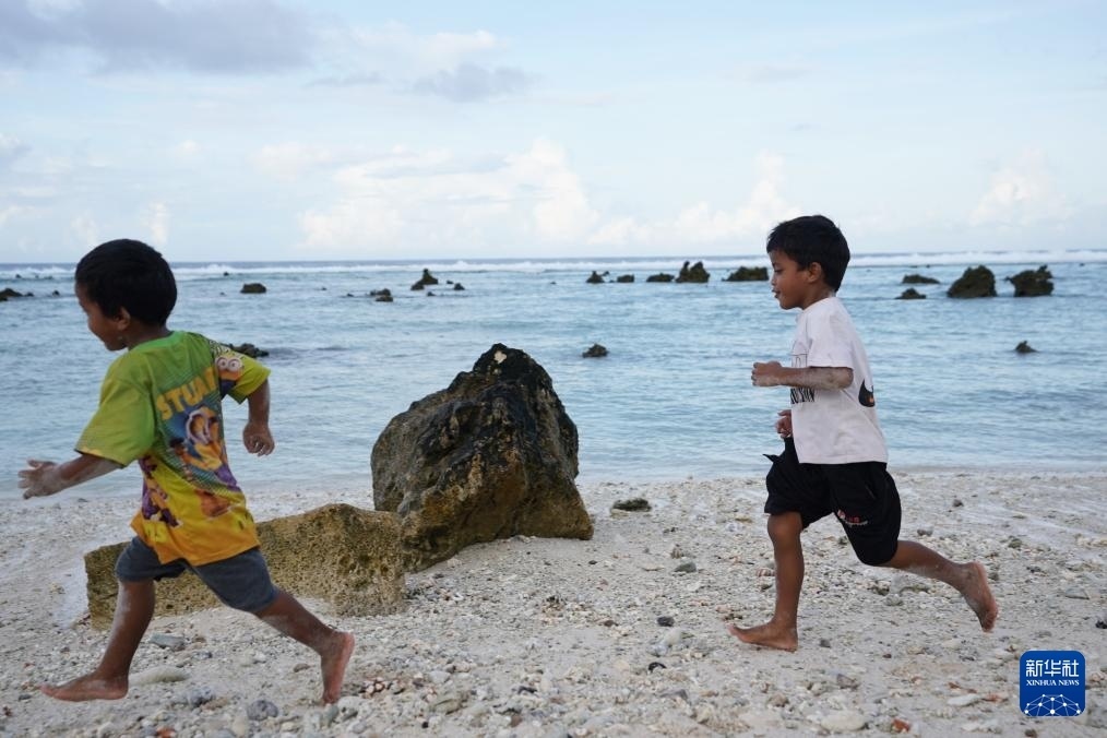 1月20日，兒童在瑙魯海邊嬉戲。新華社記者 王申 攝