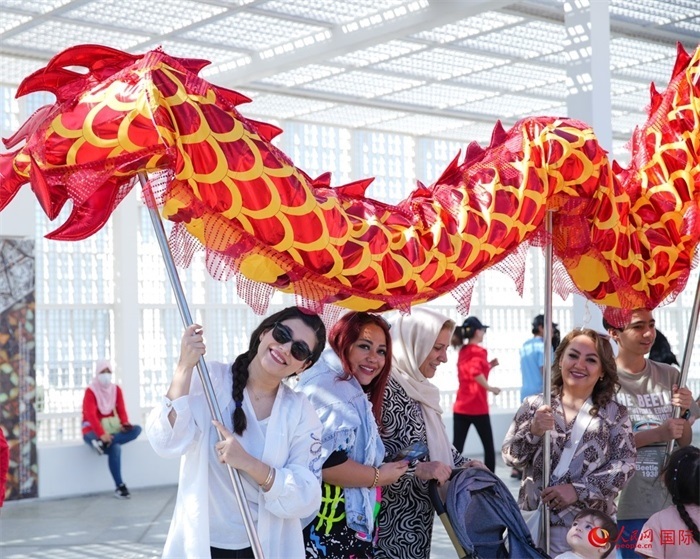 游客體驗(yàn)舞龍。 人民網(wǎng) 塔里克·易卜拉欣攝