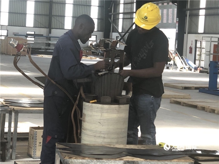 經(jīng)貿(mào)合作區(qū)廠房內，當?shù)毓と苏诰o張作業(yè)。人民網(wǎng)記者 黃培昭攝