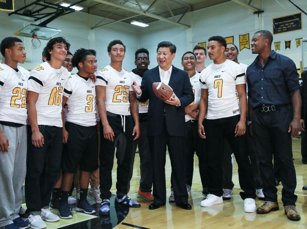 2015年9月23日，國家主席習(xí)近平參觀美國塔科馬市林肯中學(xué)。這是習(xí)近平在學(xué)校體育館，同上橄欖球訓(xùn)練課的學(xué)生們親切交談。新華社記者 蘭紅光 攝