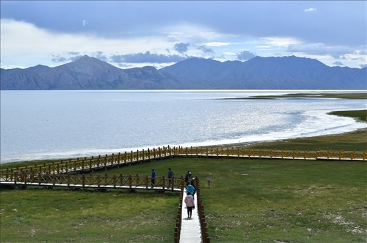 △ 游客行走在青?，敹嗫h冬格措納湖畔的木棧道上。