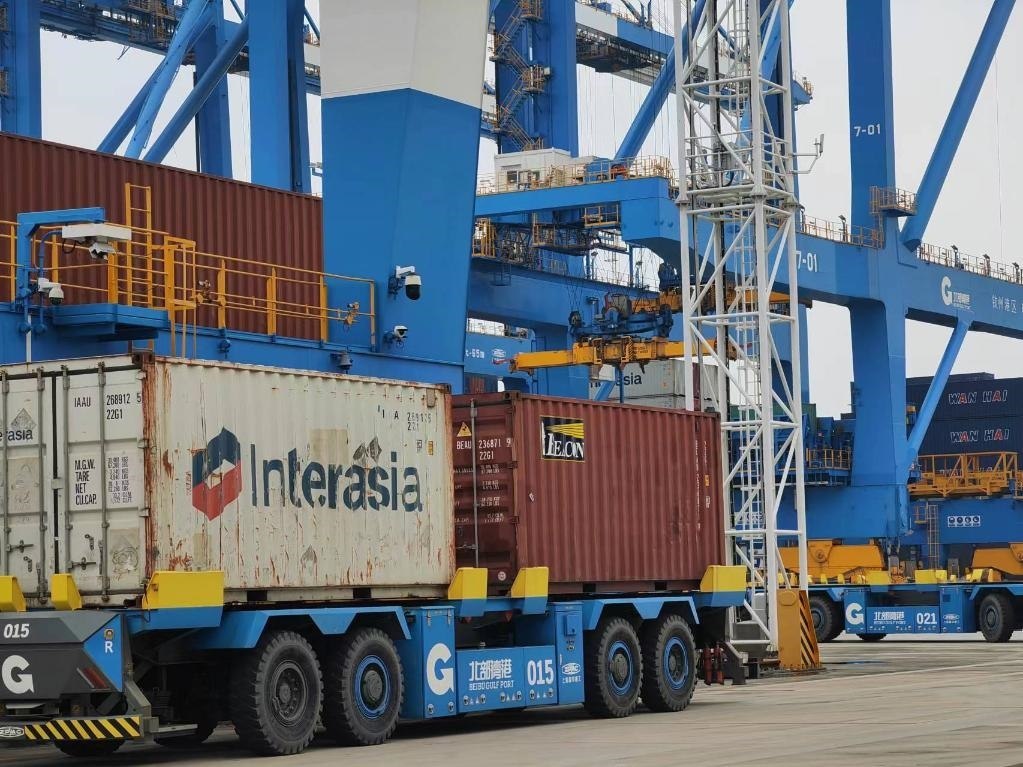 在欽州自動(dòng)化集裝箱碼頭，智能導(dǎo)引運(yùn)輸車在運(yùn)送集裝箱。新華社記者趙歡 攝