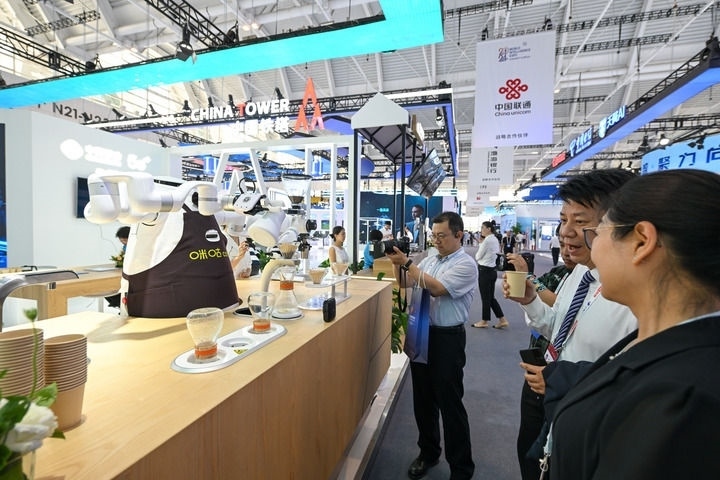 6月20日，與會者品嘗機器人沖調(diào)出的咖啡。新華社記者 孫凡越 攝