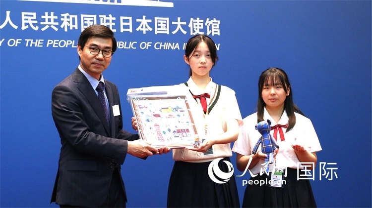 日本小大使向中國駐日本大使館臨時代辦施泳贈送當?shù)靥厣Y品。人民網(wǎng) 許可攝