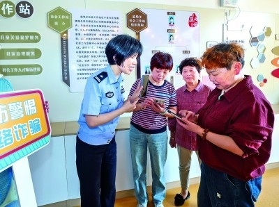 浙江湖州民警指導居民加入湖州“e企安”微信群，實時接收反詐信息。新華社發(fā)