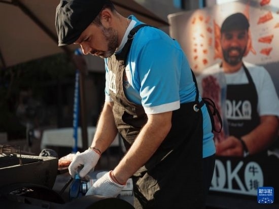 7月19日，在蕪湖古城，馬丁在當(dāng)天舉行的啤酒節(jié)上制作牛排。新華社發(fā)（繆雨晨 攝）