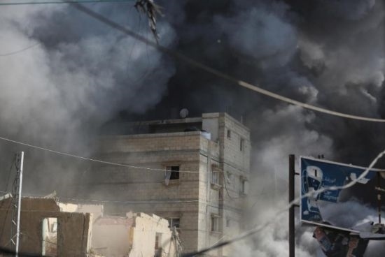 7月21日，在加沙地帶中部的努賽賴特難民營(yíng)，遭以軍空襲的建筑冒出滾滾濃煙。新華社發(fā)（馬爾萬(wàn)·達(dá)烏德攝）