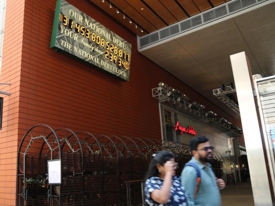 2023年5月29日，人們經(jīng)過美國(guó)紐約曼哈頓的“國(guó)債鐘”?！皣?guó)債鐘”是一個(gè)大型計(jì)數(shù)器，它實(shí)時(shí)更新美國(guó)的公共債務(wù)總額，并顯示出每個(gè)美國(guó)家庭所要負(fù)擔(dān)的數(shù)額。 新華社記者劉亞南攝