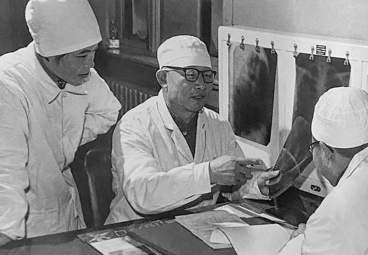 1980年1月16日，中日友好醫(yī)院首任院長辛育齡（中）在內(nèi)蒙古結(jié)核病院與胸外科醫(yī)師討論病例（翻拍照片）。 新華社發(fā)