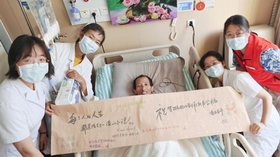 7月26日，海淀醫(yī)院安寧療護(hù)科醫(yī)護(hù)團(tuán)隊(duì)為朱銳送來一條寫滿祝福的橫幅。（受訪者供圖）