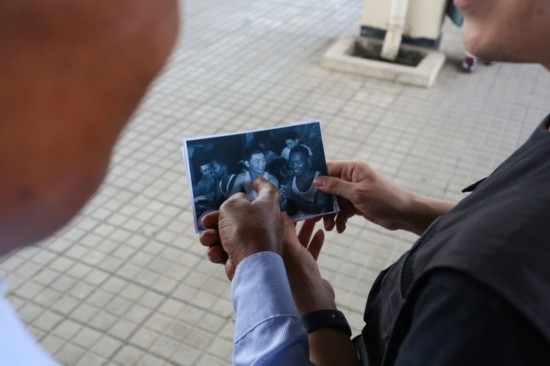 恩貢亞尼在看坦贊鐵路建設(shè)時期拍攝的老照片。