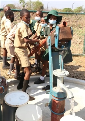 △2021年11月，在津巴布韋南馬塔貝萊蘭省省會(huì)關(guān)達(dá)的塞農(nóng)多小學(xué)，學(xué)生從中國援建水井里打水。