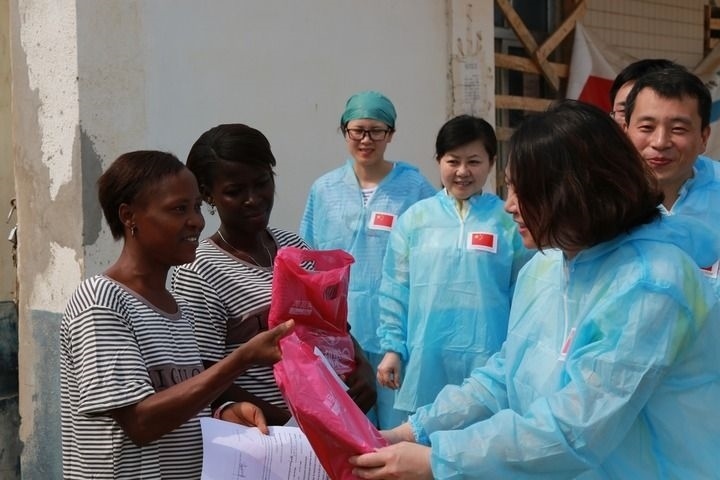 2015年4月4日，在位于塞拉利昂首都弗里敦市郊的中塞友好醫(yī)院埃博拉診療中心，中國(guó)第四批援塞醫(yī)療隊(duì)副隊(duì)長(zhǎng)邵蔚（右前）向被治愈的埃博拉出血熱患者贈(zèng)送禮物。新華社發(fā)（祖榮強(qiáng) 攝）