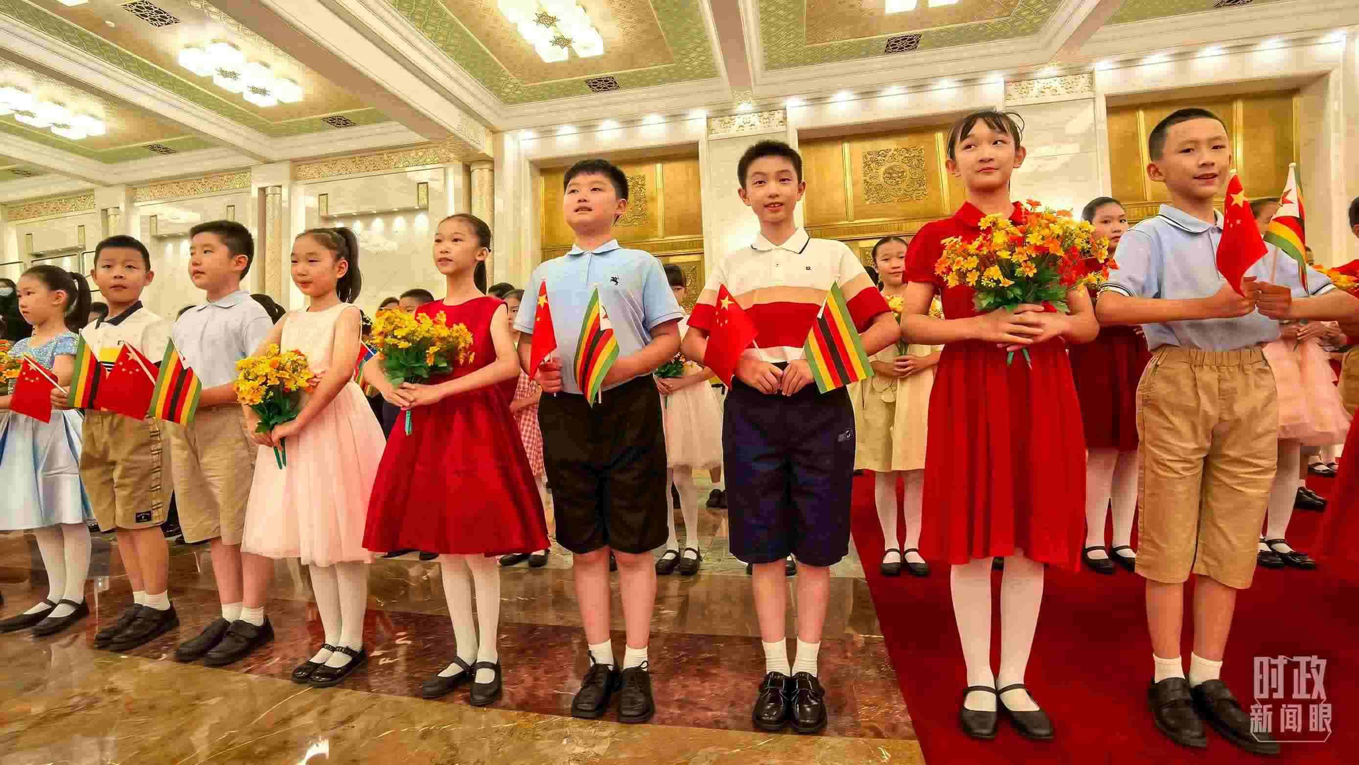 △現(xiàn)場(chǎng)歡迎津巴布韋總統(tǒng)訪華的青少年。（總臺(tái)央視記者鐘銳拍攝）