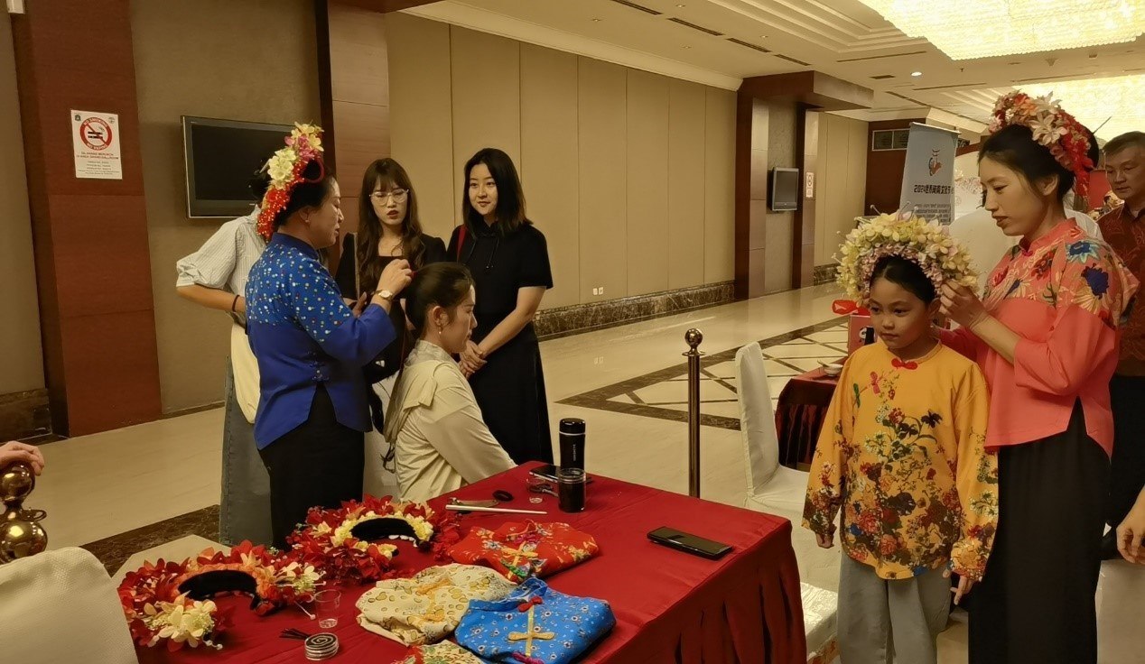 阿拉扎大學孔子學院志愿者老師向傳承人學習簪花圍。阿拉扎大學孔子學院供圖