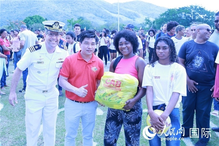 巴西中國浙江商會會長鄭俠茂向巴西貧困社區(qū)兒童及家庭捐贈基礎(chǔ)食品籃子和足球。人民網(wǎng)記者陳海琪 攝