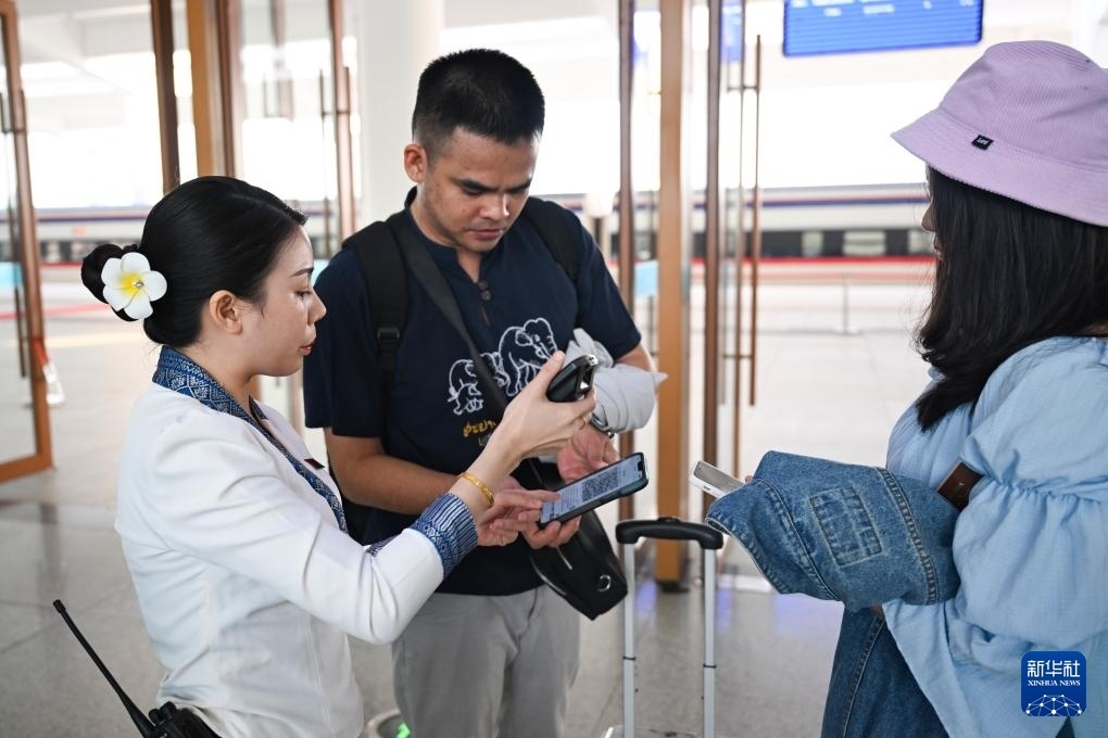10月12日，在老撾萬象中老鐵路萬象站，工作人員檢驗乘客車票。新華社記者 程一恒 攝