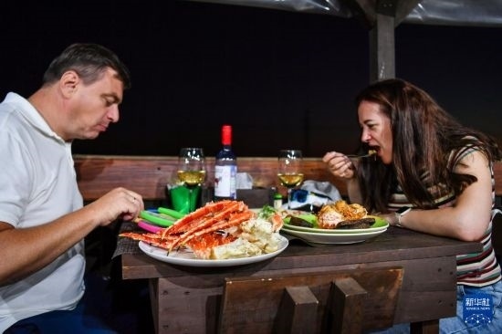 9月2日，食客們在俄羅斯符拉迪沃斯托克的一家餐館品嘗帝王蟹。新華社記者 曹陽 攝