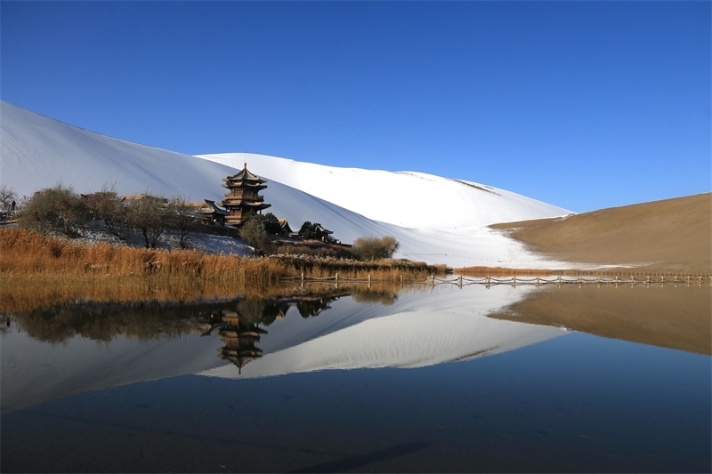 鳴沙山月牙泉景區(qū)雪景。敦煌市委宣傳部供圖，張曉亮攝