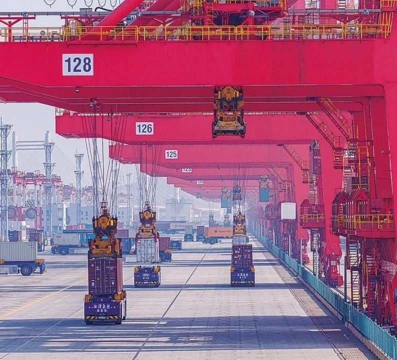 共建“一帶一路”國(guó)家在工作制度對(duì)接、技術(shù)標(biāo)準(zhǔn)協(xié)調(diào)、檢驗(yàn)結(jié)果互認(rèn)等方面強(qiáng)化合作、統(tǒng)一標(biāo)準(zhǔn)，貿(mào)易自由化便利化水平不斷提升。上海洋山港海關(guān)對(duì)接共建國(guó)家進(jìn)出口貨物相關(guān)標(biāo)準(zhǔn)，推動(dòng)通關(guān)一體化方式申報(bào)，提升通關(guān)效率。圖為無(wú)人駕駛的全自動(dòng)導(dǎo)引車(chē)在洋山港穿梭往來(lái)，搬運(yùn)集裝箱。王初 攝