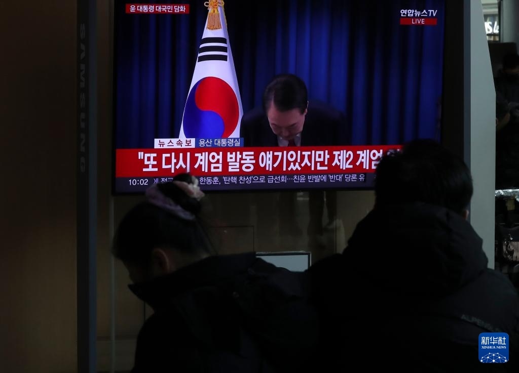 12月7日，在韓國(guó)首爾火車(chē)站，民眾觀看總統(tǒng)尹錫悅發(fā)表講話的電視畫(huà)面。新華社記者 姚琪琳 攝